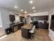 Kitchen with an island with barstool seating, stainless steel appliances, and dark cabinets at 10347 W Odeum Ln, Tolleson, AZ 85353