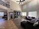 Open-concept living area features a soaring ceiling, large windows, and a dark sectional sofa at 10347 W Odeum Ln, Tolleson, AZ 85353
