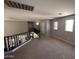 Carpeted loft space overlooks stairs, featuring three windows for natural light, and neutral wall colors at 10347 W Odeum Ln, Tolleson, AZ 85353