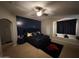 Cozy main bedroom features an accent wall, carpet, ceiling fan and a cute window nook at 10347 W Odeum Ln, Tolleson, AZ 85353