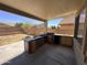 Covered patio with an outdoor kitchen, including grill and sink, perfect for outdoor entertaining at 10347 W Odeum Ln, Tolleson, AZ 85353