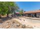Backyard with an empty pool surrounded by natural rock landscaping and mature trees at 1123 W Mendoza Ave, Mesa, AZ 85210