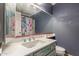 Bathroom features a vibrant floral shower curtain, a dark blue wall and white sink with counter at 1123 W Mendoza Ave, Mesa, AZ 85210