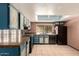 Kitchen boasting custom blue cabinets, granite countertops and black appliances at 1123 W Mendoza Ave, Mesa, AZ 85210