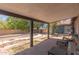 Covered patio overlooking a backyard featuring an empty pool and landscaping with trees at 1123 W Mendoza Ave, Mesa, AZ 85210