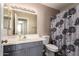A full bathroom features a single sink vanity, toilet and a bathtub with a floral shower curtain at 11352 E Dartmouth St, Mesa, AZ 85207