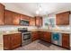 Well-lit kitchen featuring wood cabinets, stainless steel appliances, granite counters, and stylish tile flooring at 11352 E Dartmouth St, Mesa, AZ 85207