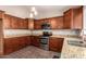 Well-lit kitchen features granite countertops, stainless appliances, and wood cabinets at 11352 E Dartmouth St, Mesa, AZ 85207