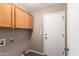 Functional laundry room with cabinets for storage and neutral paint color for a clean look at 11352 E Dartmouth St, Mesa, AZ 85207