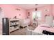 Bright Bedroom with pink walls, crib, changing table, and window at 12325 W Dreyfus Dr, El Mirage, AZ 85335