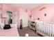 Bright pink Bedroom with pink walls, crib, and changing table at 12325 W Dreyfus Dr, El Mirage, AZ 85335