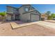 Two-story home with a two-car garage, neutral tones, desert landscaping, and covered front porch entry at 12325 W Dreyfus Dr, El Mirage, AZ 85335