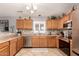 Cozy kitchen featuring wood cabinetry, stainless steel appliances, and tile backsplash at 12325 W Dreyfus Dr, El Mirage, AZ 85335