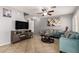 Inviting living room with stylish furnishings, tile floors, ceiling fan, and cozy fireplace at 12325 W Dreyfus Dr, El Mirage, AZ 85335