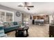 Inviting living room features a plush sofa, ceiling fan, and seamless access to the kitchen and outdoor patio at 12325 W Dreyfus Dr, El Mirage, AZ 85335