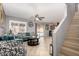 Open living room with access to backyard, tile floors, comfortable seating, stairs and ceiling fan at 12325 W Dreyfus Dr, El Mirage, AZ 85335