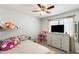 Cozy bedroom with a ceiling fan, dresser, and a large window for natural light at 1397 E Laurel Pl, Casa Grande, AZ 85122