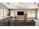 Cozy living room with large sectional, mounted TV, and sunlit windows at 1397 E Laurel Pl, Casa Grande, AZ 85122
