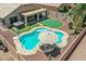 Aerial view of a backyard oasis featuring a sparkling pool, putting green, and covered patio at 1564 E Leaf Rd, San Tan Valley, AZ 85140
