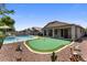 Outdoor living is easy with pool, putting green, covered patio, and rock landscaping in a verdant backyard at 1564 E Leaf Rd, San Tan Valley, AZ 85140