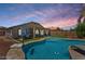 Gorgeous backyard with a pool, putting green, and covered patio, perfect for outdoor living and entertaining at 1564 E Leaf Rd, San Tan Valley, AZ 85140