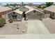 Inviting home featuring desert landscaping, well-maintained lawn, wide driveway, and an attached garage at 1564 E Leaf Rd, San Tan Valley, AZ 85140