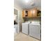 Functional laundry room equipped with a washer, dryer, and overhead storage cabinets at 1564 E Leaf Rd, San Tan Valley, AZ 85140