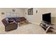 Comfortable living room with tile flooring, a large leather sofa, and a decorative rug at 1564 E Leaf Rd, San Tan Valley, AZ 85140