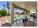 Covered patio with tiled surface is perfect for enjoying the verdant backyard with pool and putting green at 1564 E Leaf Rd, San Tan Valley, AZ 85140