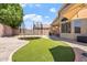 Spacious backyard with artificial grass, a trampoline, and covered patio area at 16586 W Latham St, Goodyear, AZ 85338