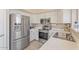 Well-lit kitchen with stainless steel appliances, white cabinets, and a stainless steel sink at 16586 W Latham St, Goodyear, AZ 85338
