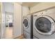 Convenient laundry room with front-load washer and dryer and a doorway to another room at 16586 W Latham St, Goodyear, AZ 85338