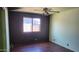 Bedroom with a ceiling fan, laminate floors, and a large window at 17458 N 64Th Dr, Glendale, AZ 85308