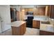 A cozy kitchen featuring oak cabinets, an island, and stainless steel appliances at 17458 N 64Th Dr, Glendale, AZ 85308