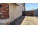 A view of the side yard with a metal gate, tan stucco wall, and gravel ground covering at 17458 N 64Th Dr, Glendale, AZ 85308