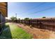 Backyard featuring a green lawn, wooden fence, gravel, and sprinkler system at 1747 W Devon --, Mesa, AZ 85201