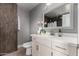 Bright bathroom featuring a vanity with white countertop, framed mirror, and gray walls at 1747 W Devon --, Mesa, AZ 85201