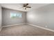 Bright carpeted bedroom features neutral walls, a ceiling fan, and a large window at 1747 W Devon --, Mesa, AZ 85201