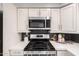 Updated kitchen features stainless steel appliances, white cabinetry, and quartz countertops at 1747 W Devon --, Mesa, AZ 85201