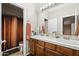 Bathroom featuring double sinks, white tile counters, and a shower with an orange-toned curtain at 1753 N St Francis Pl, Casa Grande, AZ 85122