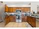 Traditional-style kitchen with wood cabinets, tile flooring, stainless steel appliances, and dark countertops at 1753 N St Francis Pl, Casa Grande, AZ 85122