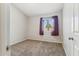 Simple bedroom featuring neutral carpet, paint, a window with curtains, and paneled door at 18819 N 49Th Ave, Glendale, AZ 85308