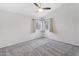 Bright bedroom featuring neutral walls, plush carpet, ceiling fan, and natural light from two windows at 18819 N 49Th Ave, Glendale, AZ 85308