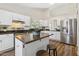 A modern kitchen with white cabinetry, stainless steel appliances and an island with seating for two at 18819 N 49Th Ave, Glendale, AZ 85308