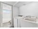 Well-lit laundry room featuring new appliances, tile floor and an adjoined bathroom at 18819 N 49Th Ave, Glendale, AZ 85308