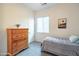 Cozy bedroom featuring a wooden dresser with drawers, a window, and a comfortable bed at 19598 E Walnut Rd, Queen Creek, AZ 85142