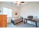 Bright bedroom with a comfortable bed, a ceiling fan, and a wooden desk for a cozy, functional space at 19598 E Walnut Rd, Queen Creek, AZ 85142