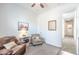 Spacious bedroom with a ceiling fan, comfortable seating, and a door to the hallway at 19598 E Walnut Rd, Queen Creek, AZ 85142