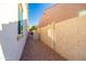 Narrow side yard shows a utility box, rock landscaping, and a stucco block fence for added privacy at 19598 E Walnut Rd, Queen Creek, AZ 85142