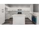 Modern kitchen featuring white cabinets, stainless appliances, a center island, and gray wood floors at 20919 E Desert Hills Blvd, Queen Creek, AZ 85142